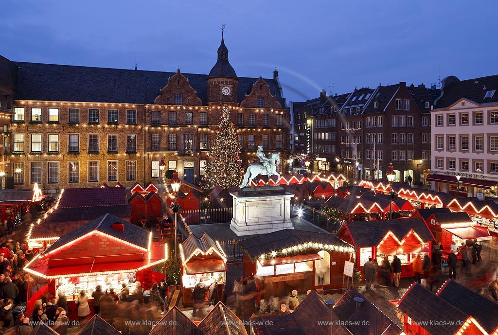 Duesseldorf Altstadt Markt Blick ueber den Weihnachtsmarkt mit Jan Wellem Reiterstandbild, dem Johann Wilhelm von der Pfalz Denkmal und einem geschmueckten Weihnachtsbaum zum Rathaus waehrend der blauen Stunde illuminiert; Old town market place with Christmas market,  Chrismas tree, Jan Wellem memorial and guildhall during blue houre illuminated