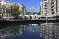 Blick auf den Hauptbahnhof in Dsseldorf, Duesseldorf-Innenstadt mit Sicht auf Skulpturen und Menschen und Spiegelbild vom Bahnhofsgebaeude im Teich