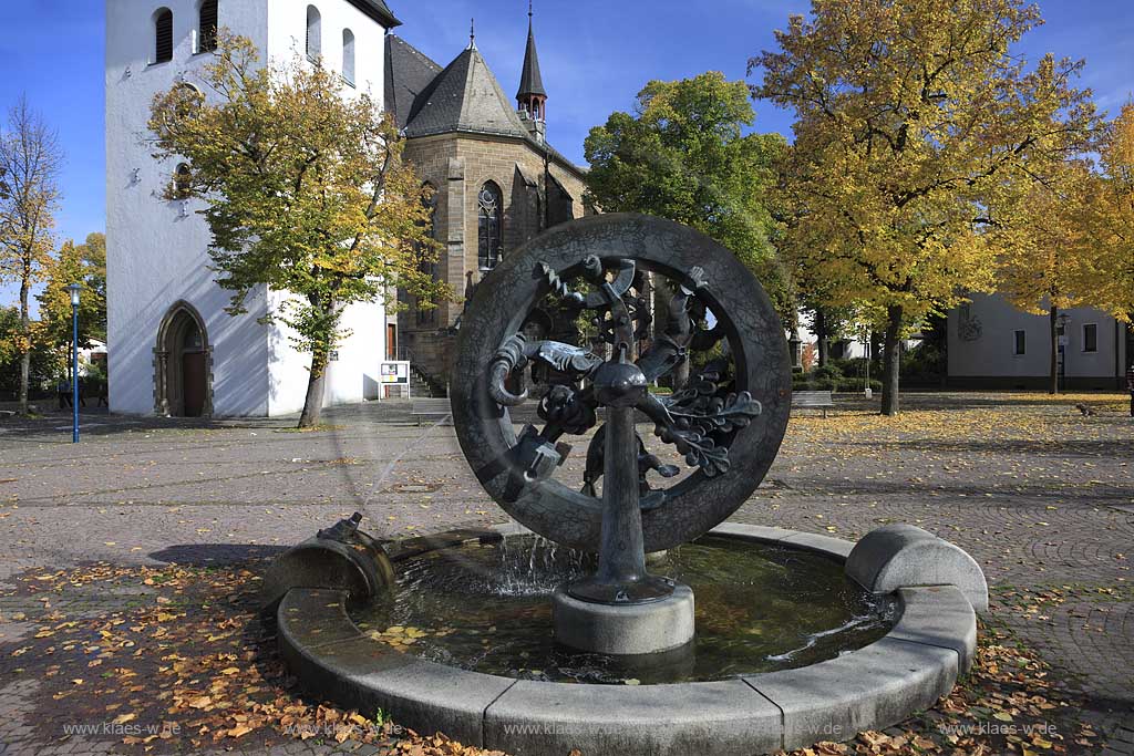 Das Wasserrad des  1993 von dem Knstler Reinhold Schrder geschaffene Marktbrunnen auf dem Kirchplatz in Arnsberg Hsten Huesten soll die Entwicklung Hstens versinnbildlichen: Landwirtschaft und Industrie die Speichen, die in den Speichen angeordneten Figurgern verkrpern mit dem Httenwerker die Industire mit dem Baum die Forstwirtschaft mit derZiege die Tierzucht mit der Buerin die Landwirtschft daber hinaus verkoerpern Roboter und Satelit die Technologie bzw. Raumfahrt vor der katholischen neugotischen Pfarrkirche St. Petri