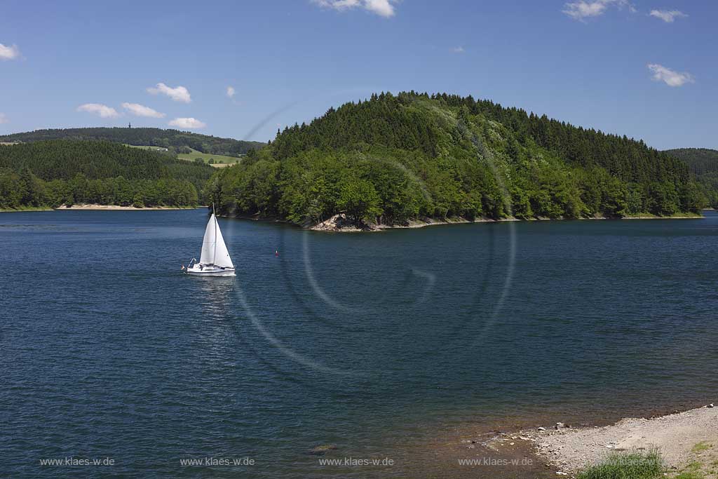 Aggertalsper, Blick von Sueden zur Halbinsel Burg Zinne zwischen dem Agger und Genkelarm, einem Segwelboot und dem Unnenbergturm am Horizont bei klarem Wetter mit blauem Himmel, wenigen Wolken in Fruehsommerlandschaft; Agger dam view over the barrage with a sailboat in summer landscape, Unnenberg look out at the horizon, blue sky few clouds