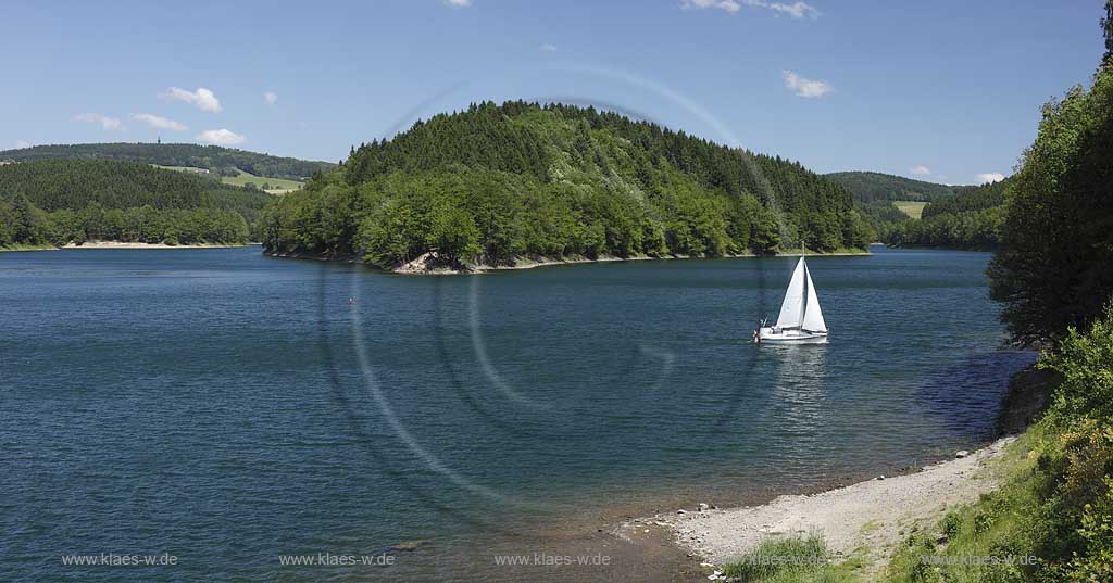 Aggertalsper, Blick von Sueden zur Halbinsel Burg Zinne zwischen dem Agger und Genkelarm, einem Segwelboot und dem Unnenbergturm am Horizont bei klarem Wetter mit blauem Himmel, wenigen Wolken in Fruehsommerlandschaft; Agger dam view over the barrage with a sailboat in summer landscape, Unnenberg look out at the horizon, blue sky few clouds