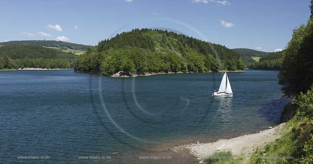 Aggertalsper, Blick von Sueden zur Halbinsel Burg Zinne zwischen dem Agger und Genkelarm, einem Segwelboot und dem Unnenbergturm am Horizont bei klarem Wetter mit blauem Himmel, wenigen Wolken in Fruehsommerlandschaft; Agger dam view over the barrage with a sailboat in summer landscape, Unnenberg look out at the horizon, blue sky few clouds