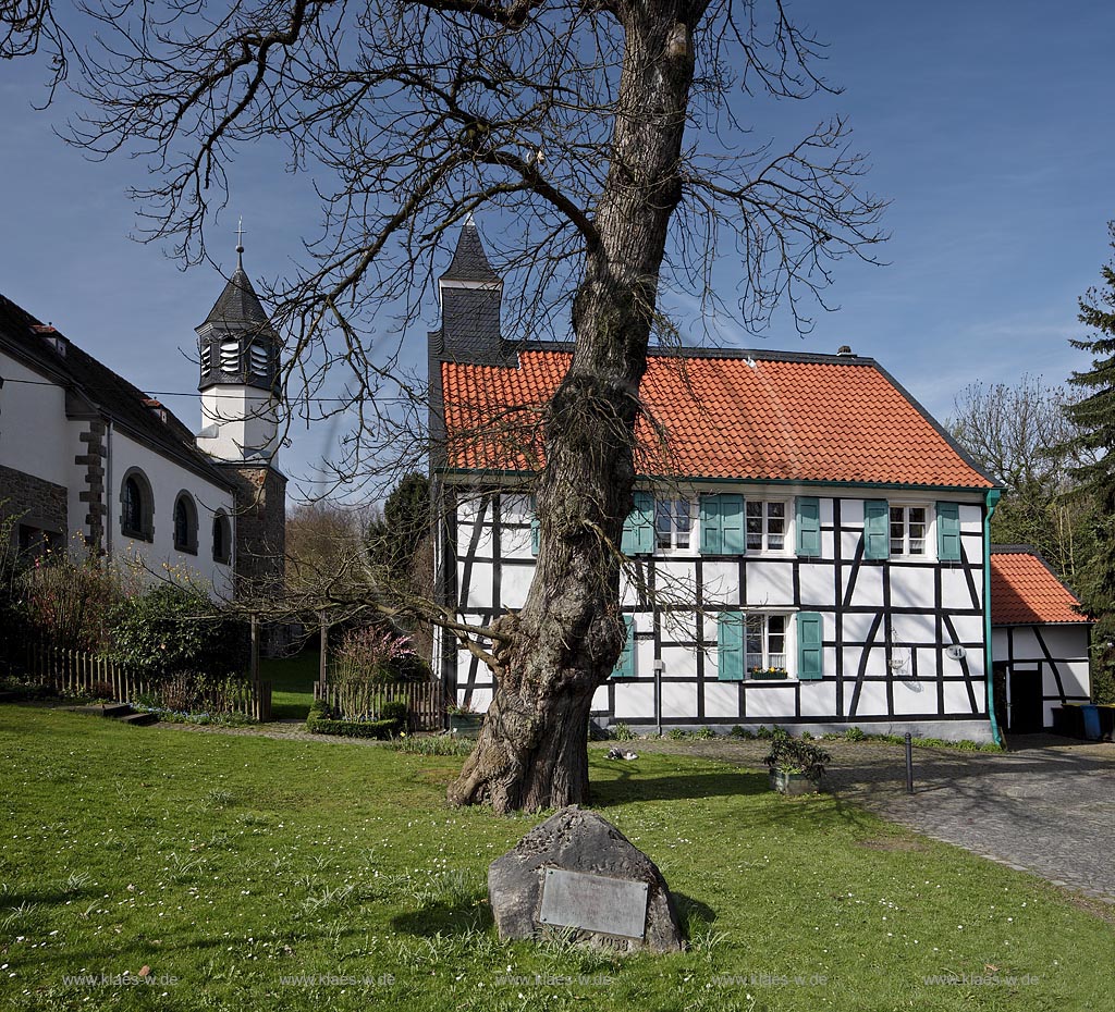 Heiligenhaus-Hetterscheid, Abtskueche. Die 1908/09 erbaute Kapelle war nicht das erste Gotteshaus in der Abtskche. Am Trmchen auf dem direkt nebenan liegenden Fachwerkhaus ist erkennbar, dass dort zuvor eine Kapelle stand. Dieses Fachwerkhaus war 1783 als Schule errichtet worden und hatte 1792 einen Anbau erhalten, der - heute nicht mehr sichtbar  den Hauptschulraum um eine Apsis erweiterte. Dieser erweiterte Raum wurde 1792 als Kapelle eingeweiht; Heiligenhaus Hetterscheid, Abtskueche, halt umbered ofd schoolhouse and chapel in Springime