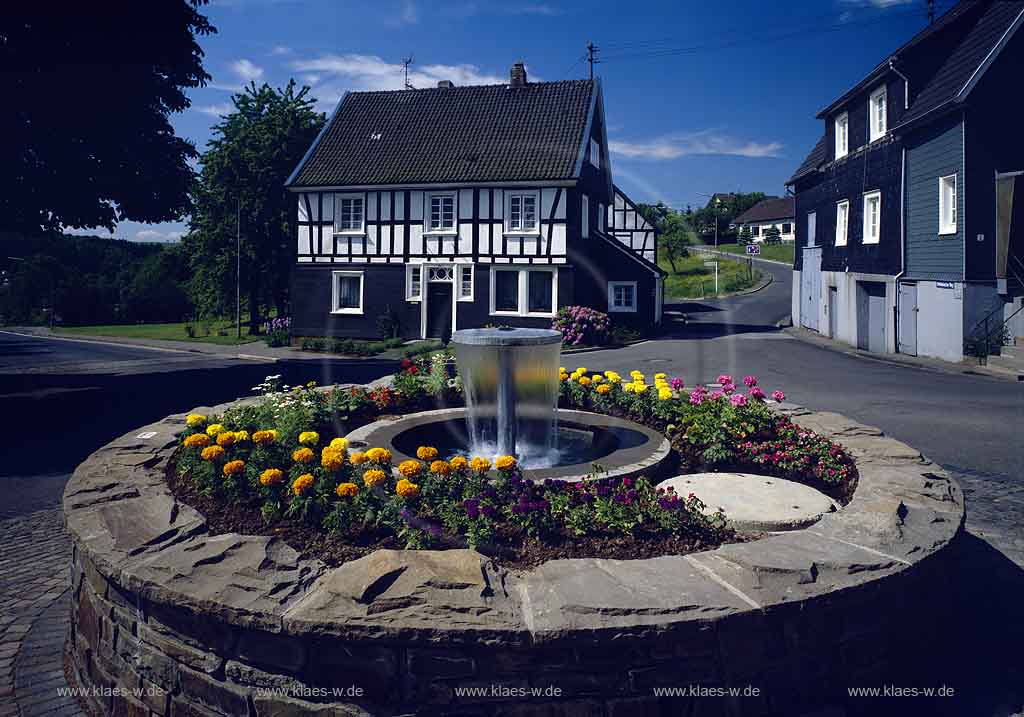 Nmbrecht, Nuembrecht, Oberbergischer Kreis, Bergisches Land, Regierungsbezirk Kln, Blick auf Dorfbrunnen, Brunnen im Ortskern mit Fachwerkhaus   