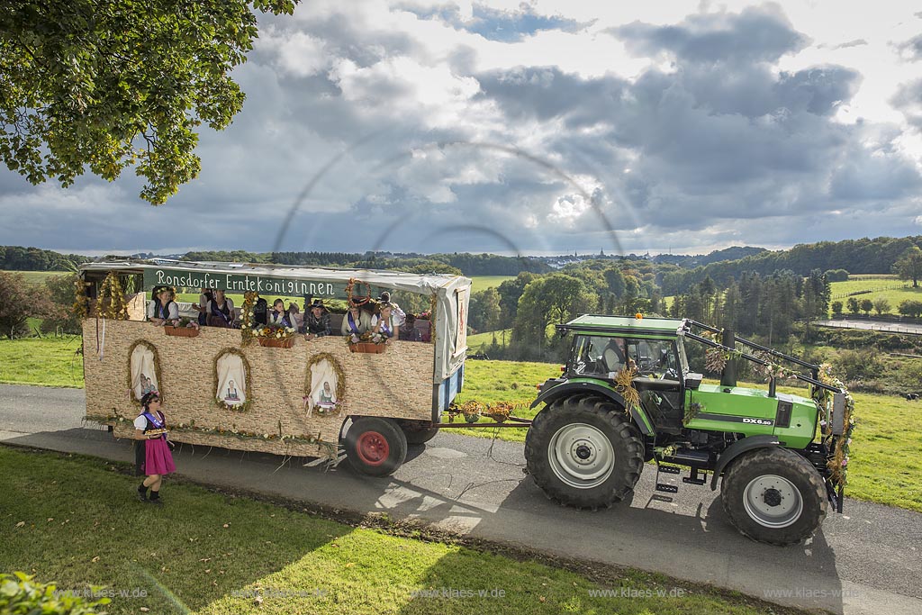 Radevormwald-Oenkfeld, Erntedankfest, Umzug mit floristisch anspruchsvoll gestaltetem und Felderzeugnissen kunstvoll dekoriertem Traktor und Erntewagen in Rochollsberg. Im fernen Hintergund die Stadtsilhouette von Radevormwald mit Ihren vier Kirchtuermen.