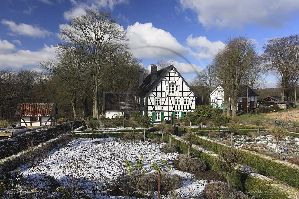 Radevormwald Lorenzhaus , Bauerngarten mit vorbildlich restauriertem Fachwerkhaus in Winterlandschaft, mit Schneeresten bei blauem Himmel mit Kumuluswolken und kahlen Baeumen, Uebergangszeit; Radevormwald half-timeberd house with farmers garden at a late winter day, rest of snow, cumulus clouds in the blue sky