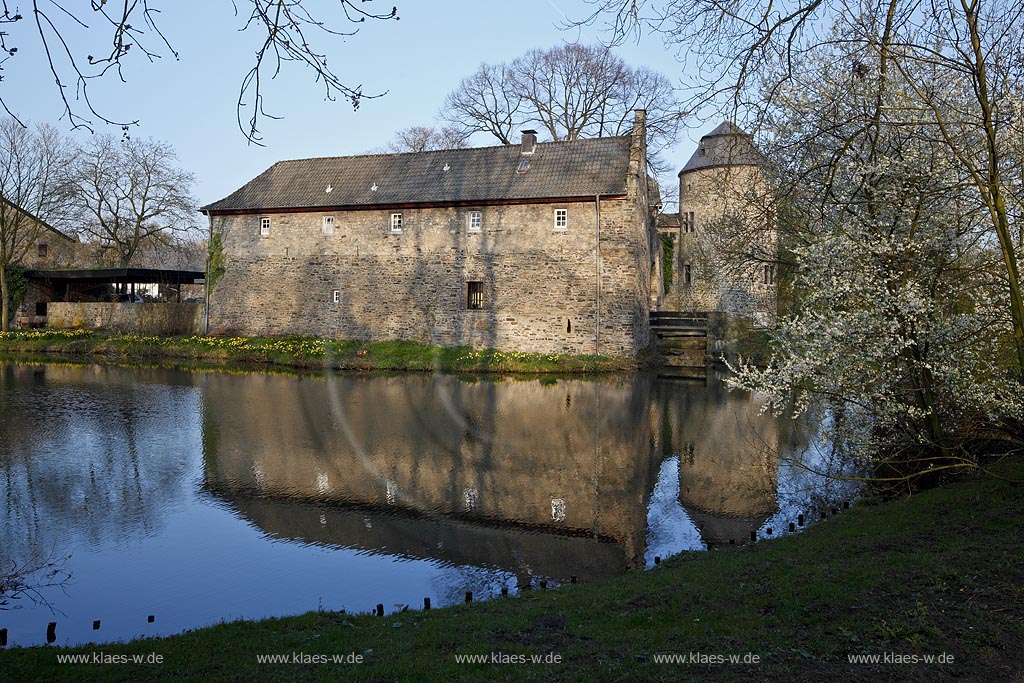 Ratingen Wasserburg Haus zum Haus mit Spiegelbild im warmen Abendlicht der untergehenden Anbendsonne im Fruehling; Ratingen moated castle Haus zum Haus (house to house) with mirror image in evening sunset light in springtime