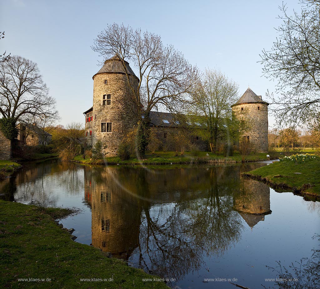 Ratingen Wasserburg Haus zum Haus mit Spiegelbild im warmen Abendlicht der untergehenden Anbendsonne im Fruehling; Ratingen moated castle Haus zum Haus (house to house) with mirror image in evening sunset light in springtime