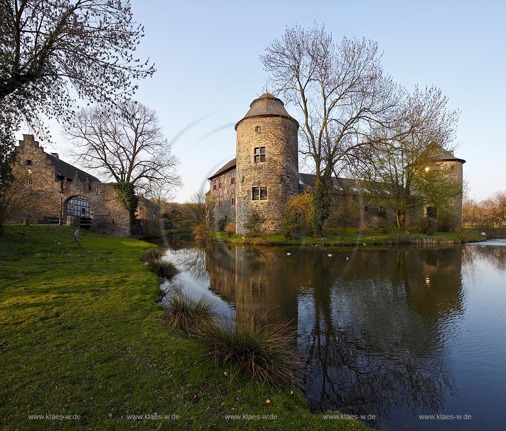 Ratingen Wasserburg Haus zum Haus mit Spiegelbild im warmen Abendlicht der untergehenden Anbendsonne im Fruehling; Ratingen moated castle Haus zum Haus (house to house) with mirror image in evening sunset light in springtime