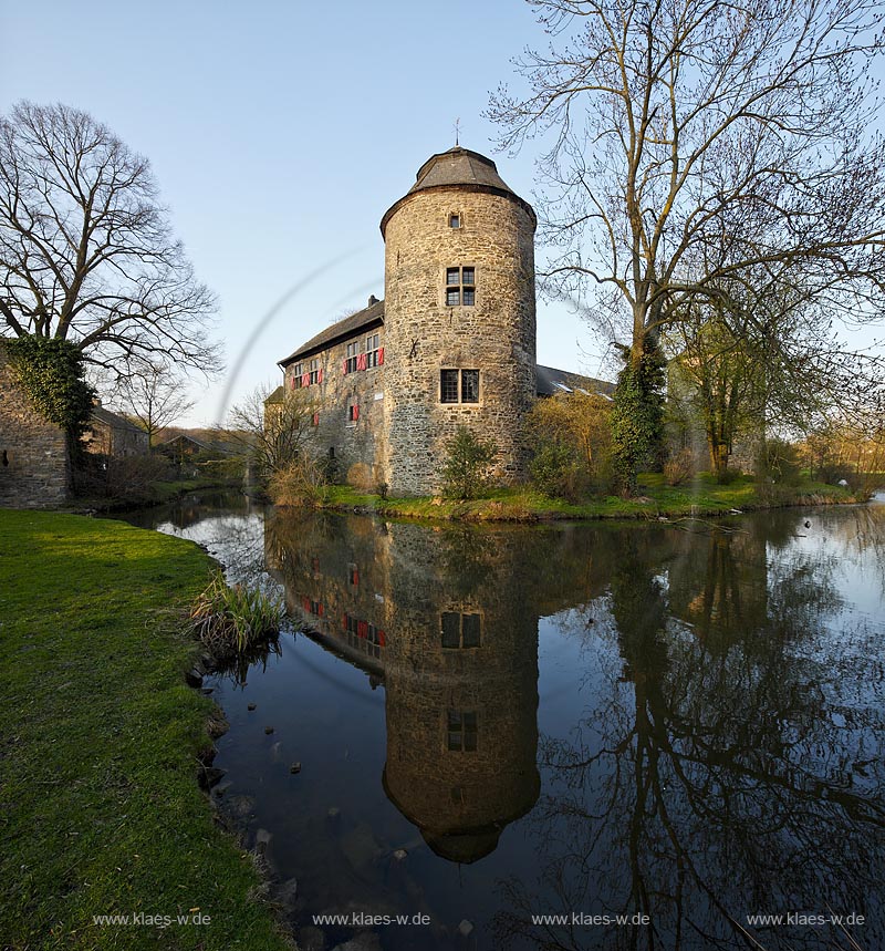 Ratingen Wasserburg Haus zum Haus mit Spiegelbild im warmen Abendlicht der untergehenden Anbendsonne im Fruehling; Ratingen moated castle Haus zum Haus (house to house) with mirror image in evening sunset light in springtime