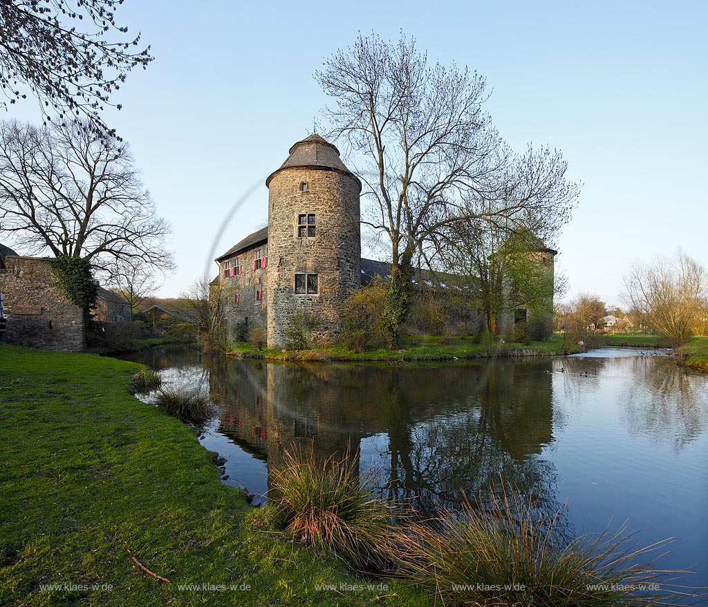 Ratingen Wasserburg Haus zum Haus mit Spiegelbild im warmen Abendlicht der untergehenden Anbendsonne im Fruehling; Ratingen moated castle Haus zum Haus (house to house) with mirror image in evening sunset light in springtime