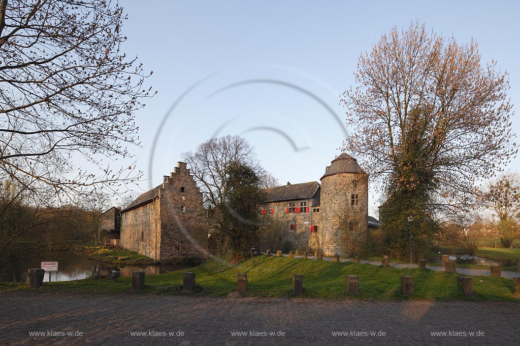 Ratingen Wasserburg Haus zum Haus im warmen Abendlicht der untergehenden Anbendsonne im Fruehling; Ratingen moated castle Haus zum Haus (house to house) in evening sunset light in springtime