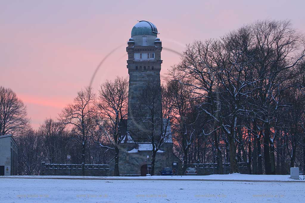 Remscheid, Blick vom Schuetzenplatzt zum Bismarkturm, heuter ein als Sternwarte genutzter 30 m hoher Turm am Remscheider Stadtpark gelegen. Er wurde als Aussichtsturm im Jahr 1901 erbaut. Waehrend des Zweiten Weltkriegs diente er als Luftschutzmeldestation. Nach dem Umbau des Obergeschosses beherbergt er heute die Hans-Schaefer-Volkssternwarte der Volkshochschule Remscheid.Bruchstein Sichtmauerwerk, Winter Abendstimmung mit Abendrot; Remscheid Bismarcktower, lookout near Townspark in Winter with snow during sunset light, afterglow in the background