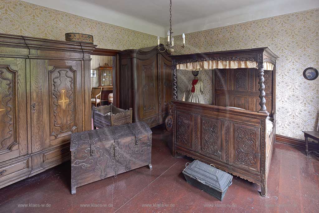 Remscheid Hasten, Haus Cleff, historisches Zentrum, Dauerausstellung in dem Barock- und Rokokochlafzimmer, welches ausgestattet ist mit antiken Moebeln wie einem Himmelbett, zwei grossen Kleiderschranken, einem Tuerrahmen, einem Babybett, einer Truhe und einem Waeschekorb ; Remscheid-Hasten, House Cleff, historcal centre, permanent exhibition in a bedroom with antiquely furniture