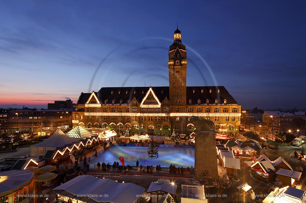 Remscheid Blick ueber den Markt mit Weihnachtsmarkt und Eislaufbahn, Schlittschuhbahn zum Rathaus, frontal waehrend der blauen Stunde, klarer Himmel in Abenstimmung mit Abendrot,  illuminiert; Guildhall of Remscheid with Christmas market illuminated during blue hour