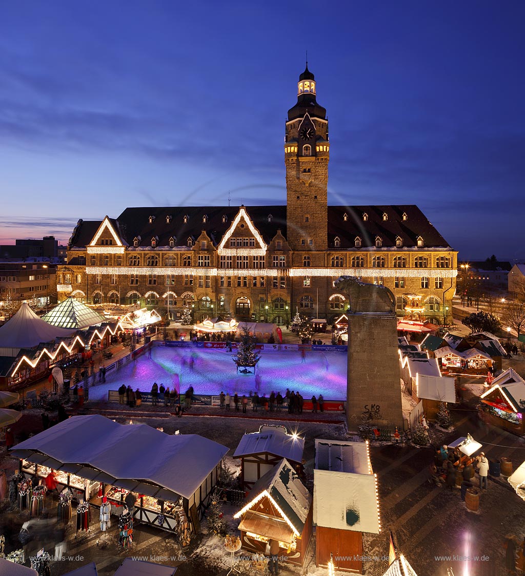 Remscheid Blick ueber den Markt mit Weihnachtsmarkt und Eislaufbahn, Schlittschuhbahn zum Rathaus, frontal waehrend der blauen Stunde, klarer Himmel in Abenstimmung mit Abendrot,  illuminiert; Guildhall of Remscheid with Christmas market illuminated during blue hour