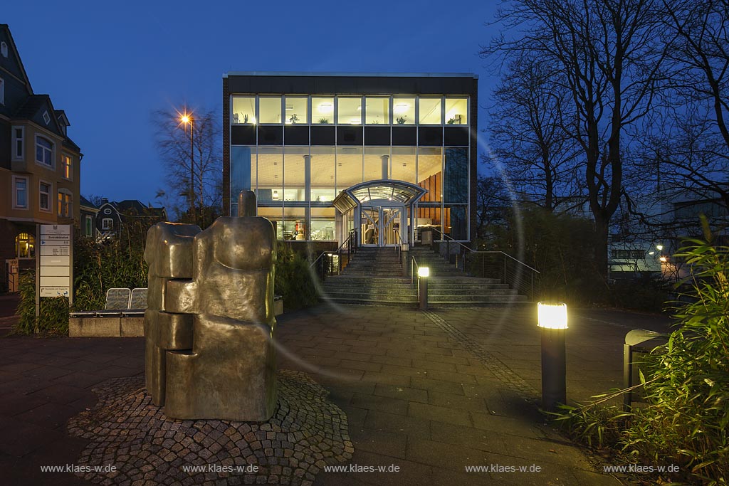 Remscheid, Zentralbibliothek zur Blauen Stunde mit Bronzeskulptur "Stammbuch" von "Hans Juergen Hiby" aus dem Jahr 1999;  Remscheid, main library at blue hour with bronze sculpture "Stammbuch" by Hans Juergen Hilby anno 1999.