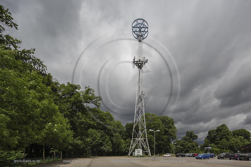 Remscheid Bliedinghausen, Mannesmann Turm, ueber einem dreieckigen Grundriss steigen drei sparsam dimensionierte Stahlrohre konkav. einge zogen nach oben auf, um sich in der Hoehe in die doppelte Kreisform des Markenzeichens "MW" auf den geringsten Abstand voneinander zu vereinigen. Regelmaessige Diagonal-Roehrenstreben fuellen diese Umrissgestalt ueber den Kreuzverbaenden des Sockelteils stabilisierend aus. Der Werbepylon ist am hoechsten Punkt 59 Meter hoch und wurde am 21.08.1961 in Betrieb genommen. Nach gegenwaertigem Kenntnisstand ist der Remscheider Turm das letzte nordrhein-westfaelische Beispiel seines Typs. Heute dient der Turm unter anderem als Sendemastanlage.Der an der Burger Strasse stehende "Mannesmann-Turm" wurde am 04.09.2002 in die Denkmalliste der Stadt Remscheid eingetragen; Remscheid Bliedinghausen, tower Mannesmann Turm.