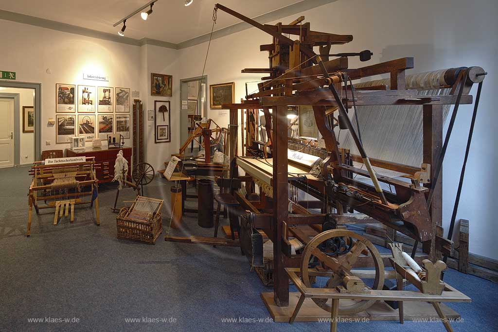 Remscheid Lennep Tuchmuseum Innenansicht Dauerausstellung Tuchmacherhandwerk - Wegbereiter der Industrialisierung. Vom handgesponnenen Faden bis zum gewebten Stueck Tuch. Ablauf der Produktion von Streichgarn, Kammgarn und der Weberei, Webstuhl im Mittelpunkt; Remscheid Lennep historcally clothier museum with hand loom.