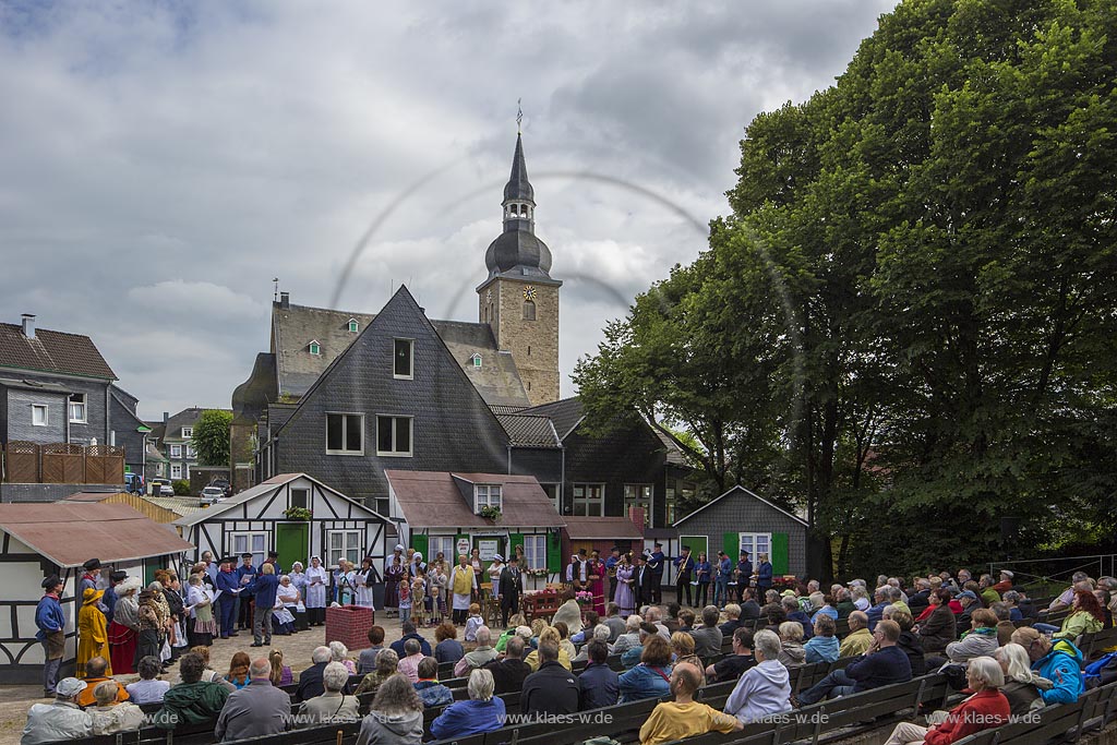 Remscheid, Luettringhausen, Bergische Heimatspiele, Volksbuehne, Blick auf die Freilichtbuehne in Luettringhausen mit Akteuren, Zuschauern und bergischen Fachwerkhaus Kulissen. Im Hintergrund Blick auf die evangelische Stadtkirche. Remscheid, Luettringhausen, Bergische Heimatspiele, Stage, With a view to the Actors and public to the open Air Stage with typical House Front dummys. In the back a look to the Church.