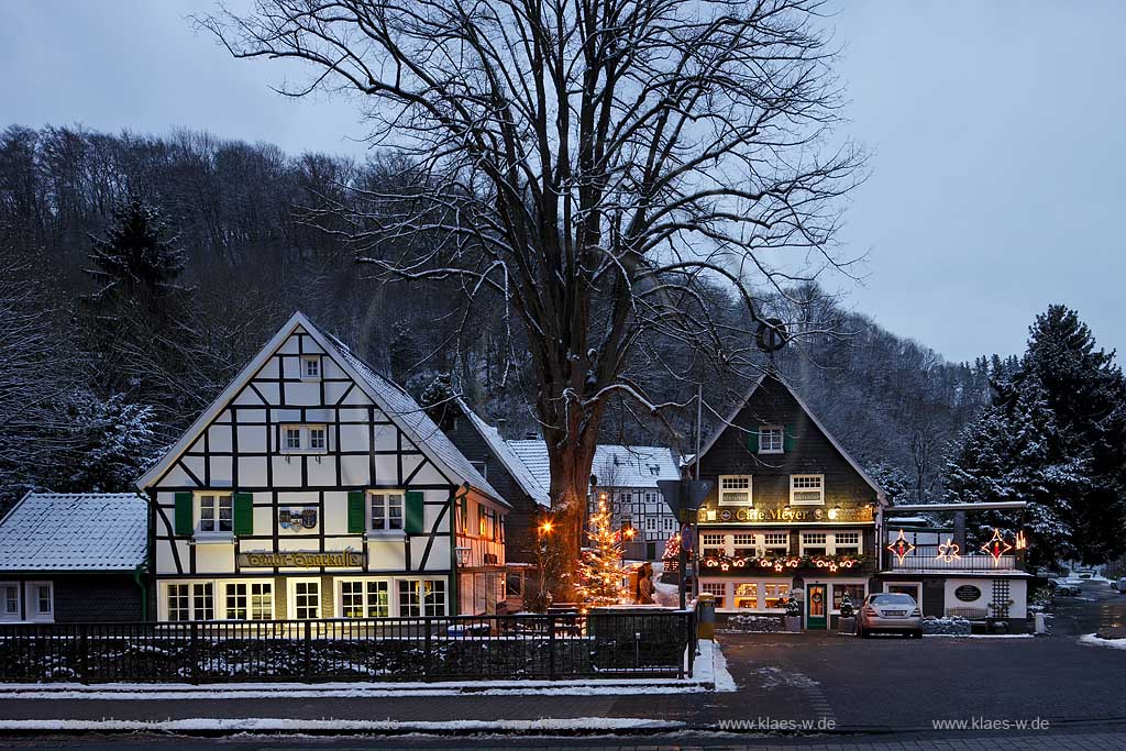 Solingen-Burg, Unterburg Weihnachtliche Stimmung zur blauen Stunde, beleuchteter Weihnachtsbaum, Fachwerkhaus alte Sparkasse, illuminiert und das verschieferte Cafe Meye rmit Burger Brezel auf dem Giebel; Solingen Burg, village Unterburg during Christmas time with Christmas tree and old half timbered bankhouse Sparkasse, illiminated