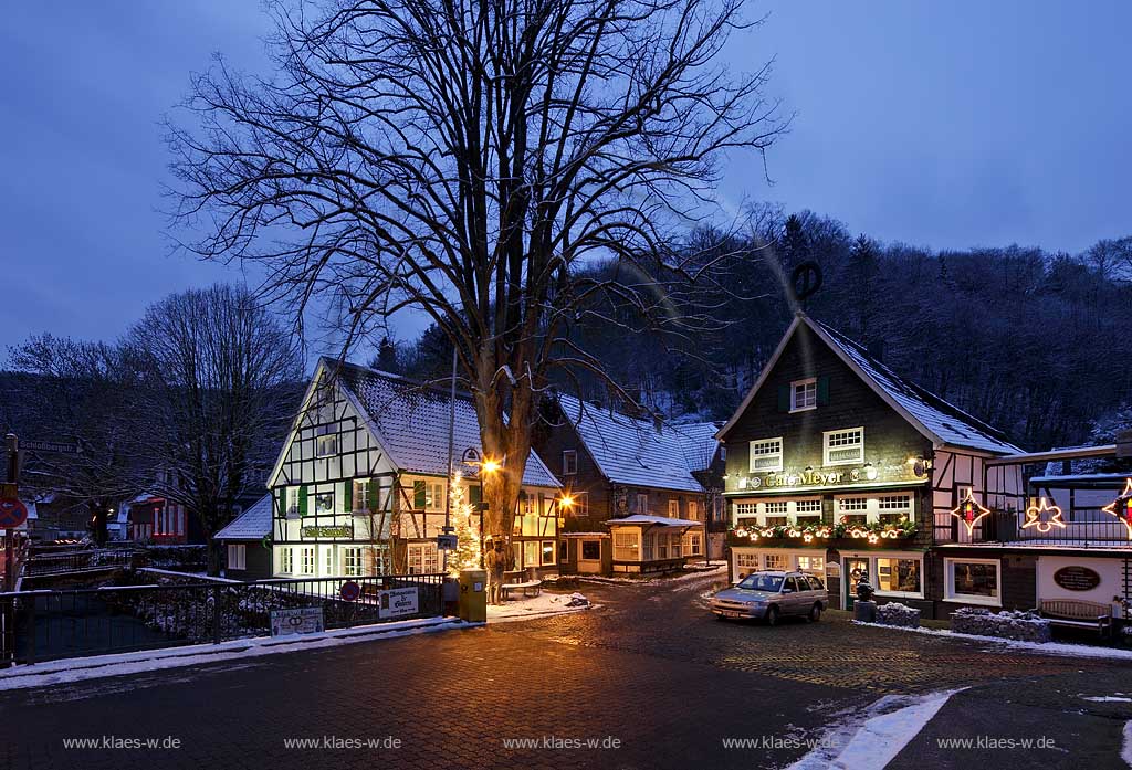 Solingen-Burg, Unterburg Weihnachtliche Stimmung zur blauen Stunde, beleuchteter Weihnachtsbaum, Fachwerkhaus alte Sparkasse, illuminiert davor der Burger Brezelbaecker, rechts das verschieferte Cafe Meye rmit Burger Brezel auf dem Giebel; Solingen Burg, village Unterburg during Christmas time with Christmas tree and old half timbered bankhouse Sparkasse, pretzel baker and cafe Meyer, illuminated