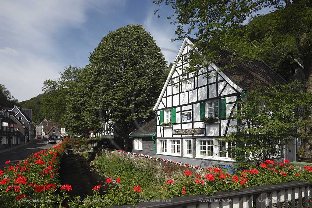 Solingen Unterburg, Schlossbergstrasse,bluehende Geranien im Vordergrund, Burger Brezelbaecker Denkmal, Stadtsparkasse Solingenr, Fachwerk- und Schieferhauser, ; Solingen-Unterburg, Schlossbergstrasse, blooming geranium , Burger pretzel baker historical monument, with frame houses and houses of shist,