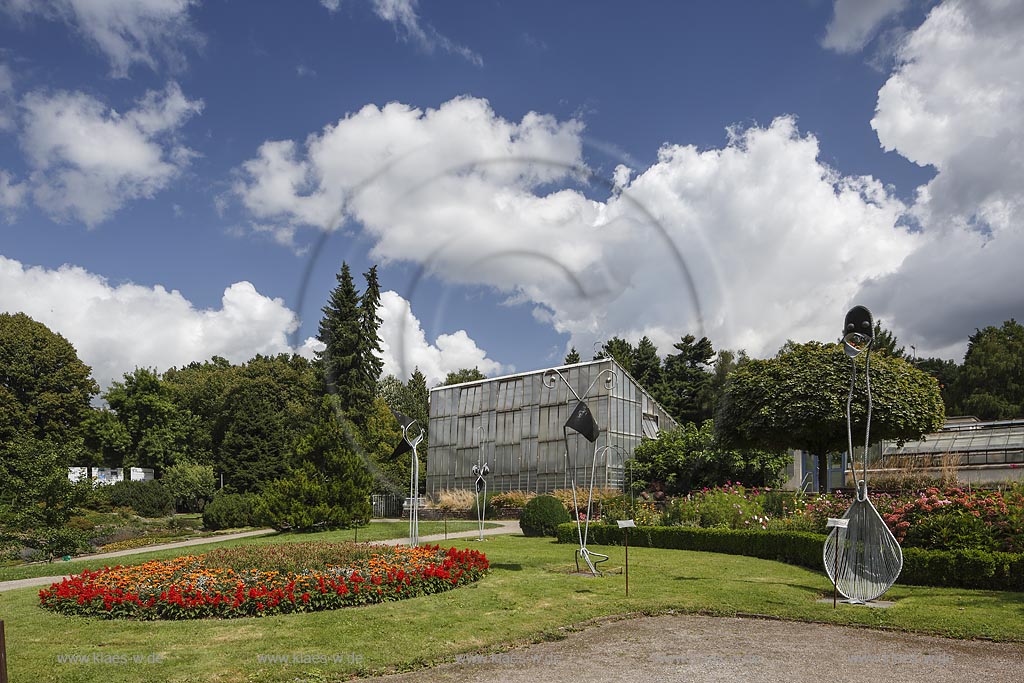 Solingen Wald, Blick in den Botanischen Garten im Sommer mit blauem Himmel und Wolken. Im Vordergrund verschiedene Skulpturen. Im Hintergrund das Tropenhaus. Solingen Wald, with a view to the Botanic garden at the Summer with blue Sky and Clouds. In the foreground different sculptures. In the Bachground the Tropic House.