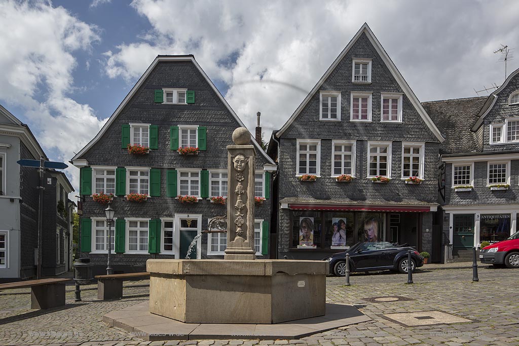 Solingen, Graefrath, Historischer Marktplatzbrunnen, Blick auf historischen Marktplatzbrunnen von 1730 und Sicht auf Buergerhaueser des achtzehnten Jahrhunderts im Sommer mit blauem Himmel und Wolken. Solingen, Graefrath, with a view to the Historic Market place fountain, build at 1730, with a look to the buergerhauser from the 18th century in the Summer with blue Sky and Clouds.