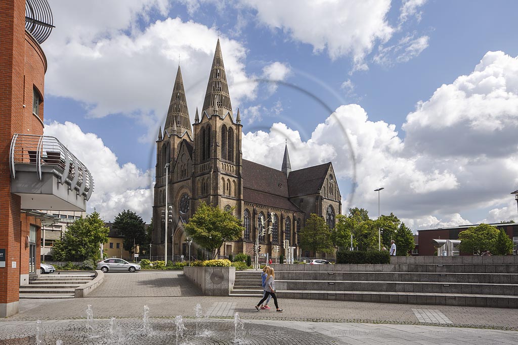 Solingen, Blick auf die St Clemens Kirche im Sommer mit blauem Himmel und Wolken, im Vordergrund Sicht auf den Muehlenplatz mit Springbrunnen und Fugaengern. Solingen, with a view to the Church St Clemens in Summer, with blue Sky and Clouds, in the foreground a view to the Muehlenplatz with a fountain and walkers.