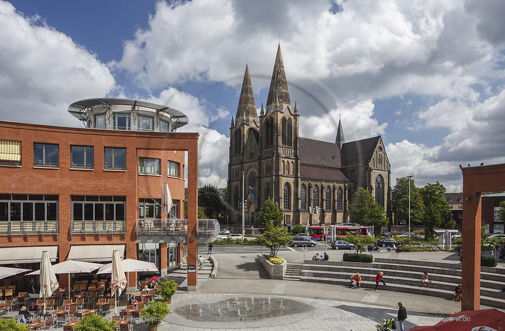 Solingen, Blick auf die St Clemens Kirche im Sommer mit blauem Himmel und Wolken, im Vordergrund Sicht auf den Muehlenplatz mit Springbrunnen und Fugaengern. Solingen, with a view to the Church St Clemens in Summer, with blue Sky and Clouds, in the foreground a view to the Muehlenplatz with a fountain and walkers.