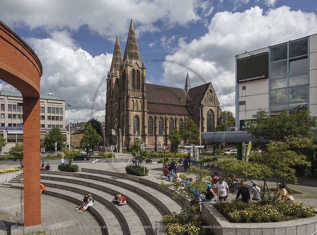 Solingen, Blick auf die St Clemens Kirche im Sommer mit blauem Himmel und Wolken, im Vordergrund Sicht auf den Muehlenplatz mit Springbrunnen und Fugaengern. Solingen, with a view to the Church St Clemens in Summer, with blue Sky and Clouds, in the foreground a view to the Muehlenplatz with a fountain and walkers.