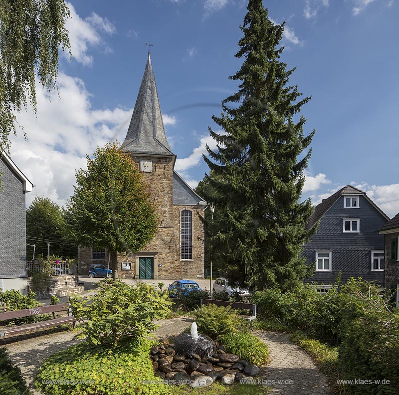 Wermelskirchen, Dabringhausen, Blick auf die evangelische Kirche im Sommer mit blauem Himmel und Wolken. Im Vordergrund ein kleiner Brunnen. Wermelskirchen, Dabringhausen, with a view to the Evangelical church in summer with blue sky and clouds. In the foreground a little fountain.