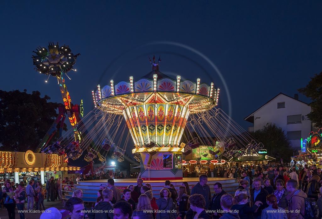 Wermelskirchen; Kettenkarussell und Hochfahrgeschaeft "Salto Mortale" der Herbstkirmes am "Loches Platz", illuminiert zur blauen Stunde; Wermelksirchen, swing carousel and "salto mortale" on the kermess, illuminated while blue hour.