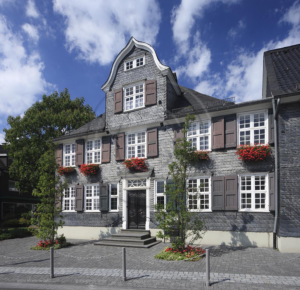 Wermelskirchen hisorisches Buergerhaus mit Schieferfassade und Giebel im Bergischen Stil Geranien Blumenschmuck an der Eich