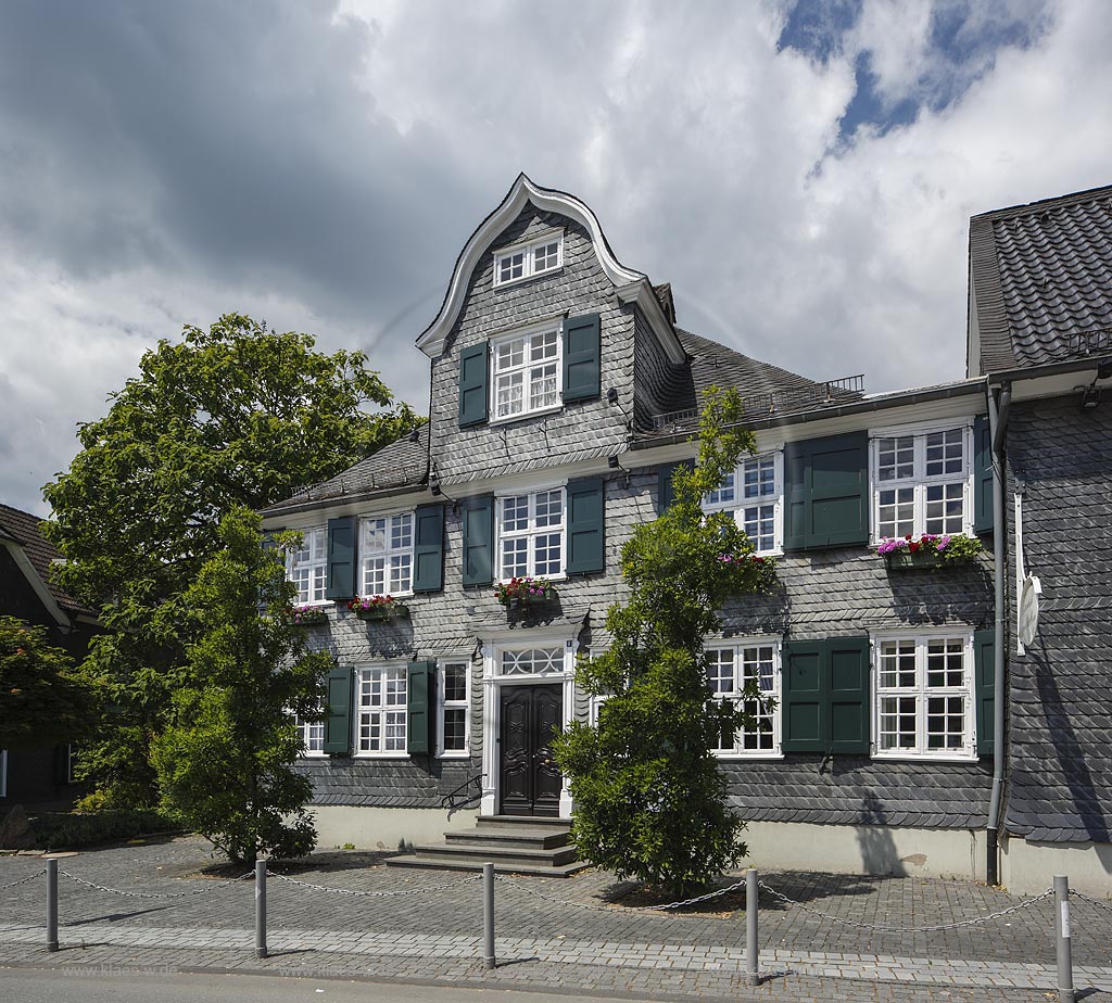 Wermelskirchen, Eiche 6 Buergerhaus, links daneben Denkmal zur Erinnerung an die Schefte und Schuhindustrie Wermelskirchen 1860-1970; Wermelskirchen, Eich 6, historical framework house split into thin sheets. left side: memorial for shoe industiy Wermelskirchen1830-1970.