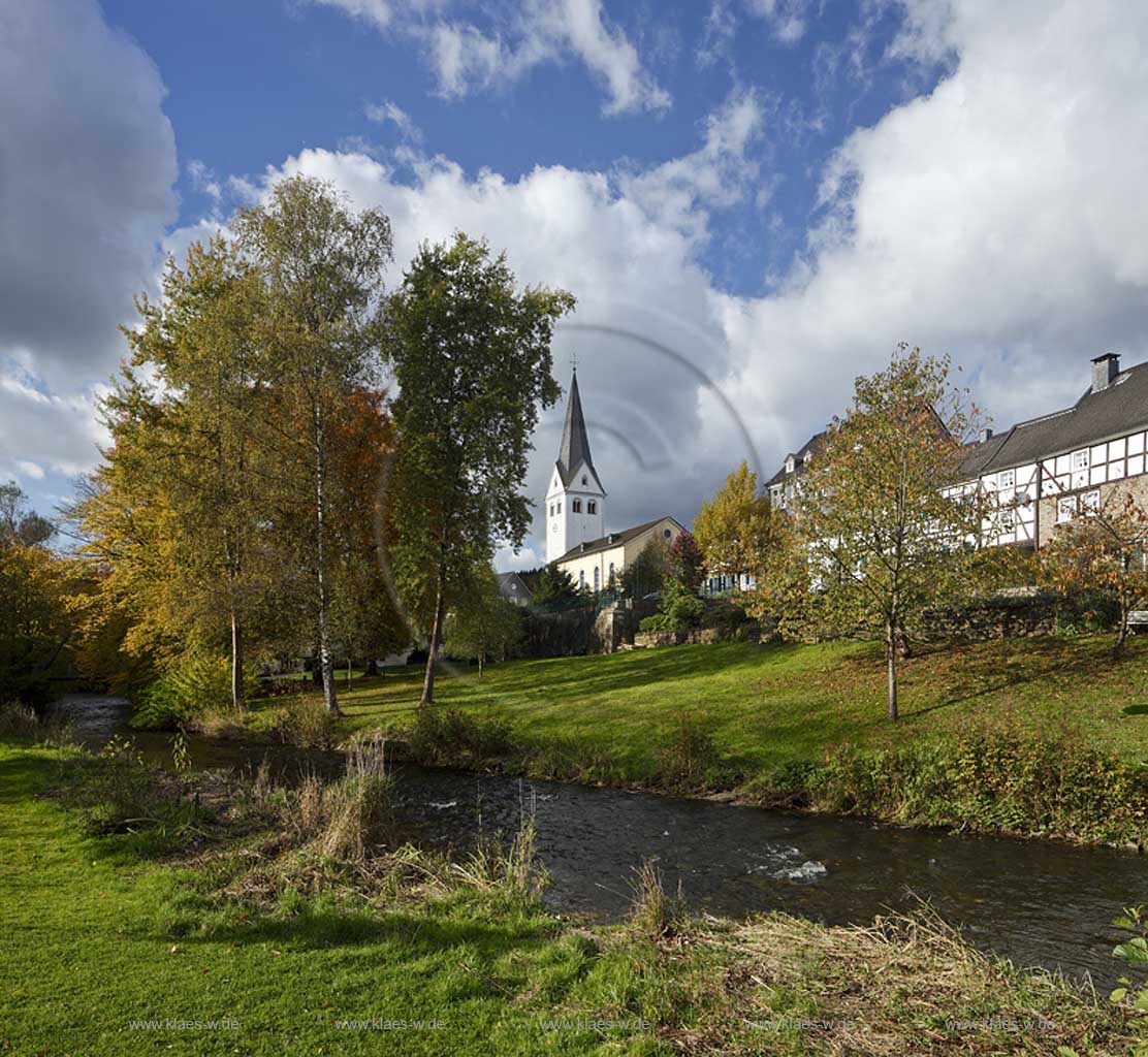 Wiehl, Blick ueber den Fluss Wiehl zur evangelischen Pfarrkirche und Fachwerkhaeusern an der Hauptstrasse in Herbstlandschaft mit Wolkenstimmung; Wiehl, view over the river Wiehl to evangelic parish church and framework houses in autumn landscape with atmospheric clouds