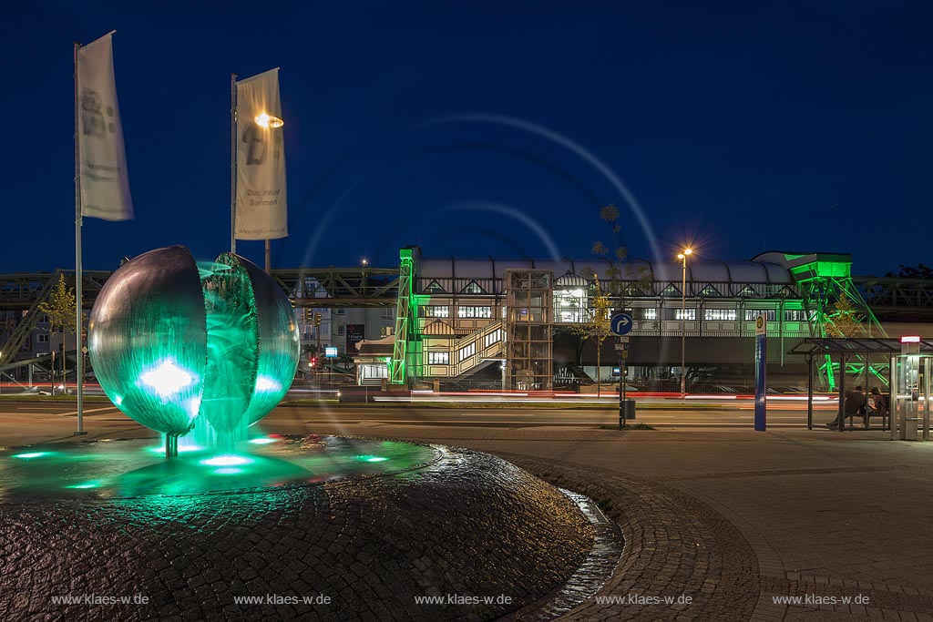 Wuppertal Barmen, Werth, Kugelbrunnen mit der Schwebebahnstation "Werther Bruecke" (im Hintergrund), illuminiert. Der 1979 von "Bert Gerresheim" erschaffene Brunnen beinhaltet 700 bronzene Figuren und 26 Reliefdarstellung und erzaehlt die Geschichte der Stadt; Wuppertal Barmen, Werth, kugel ball with station of the overhead railway (in the background) illuminated.