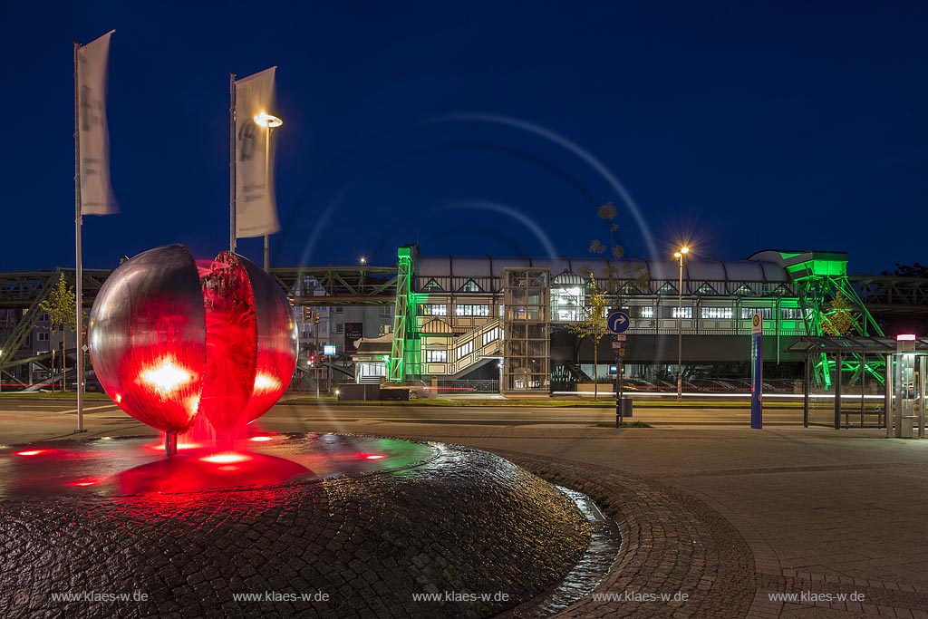 Wuppertal Barmen, Werth, Kugelbrunnen mit der Schwebebahnstation "Werther Bruecke" (im Hintergrund), illuminiert. Der 1979 von "Bert Gerresheim" erschaffene Brunnen beinhaltet 700 bronzene Figuren und 26 Reliefdarstellung und erzaehlt die Geschichte der Stadt; Wuppertal Barmen, Werth, kugel ball with station of the overhead railway (in the background) illuminated.