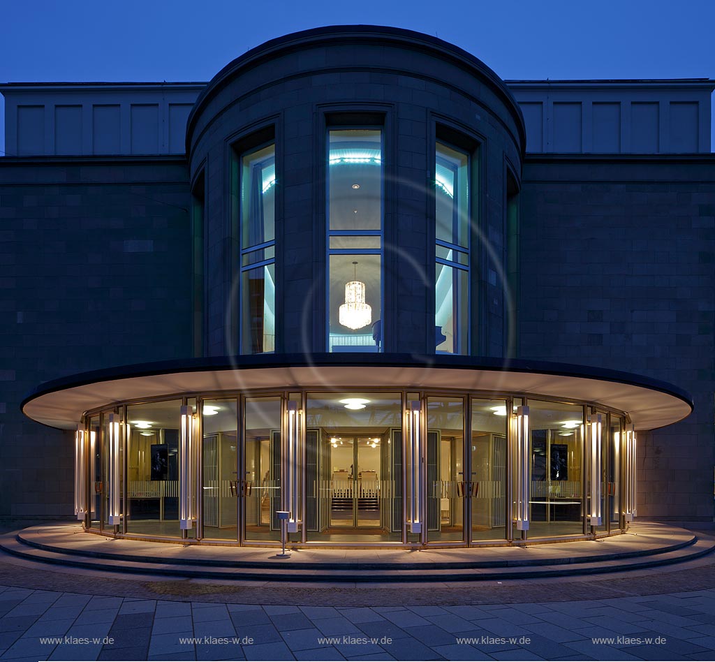 Wuppertal Barmen,das sanierte Opernhaus mit Blick auf die Front mit verglastem Eingang ins untere Foyer von innen beleuchtet, 50iger Jahre Fuenfziger Jahre Stil waehrend der blauen Stunde; Wuppertal-Barmen, front of Opera hause with glazed entrace to the illuminated foyer during blue hoeur 