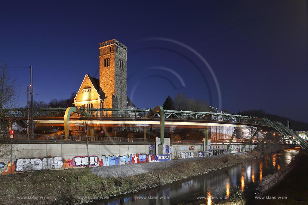 Wuppertal Elberfeld, Blick zur Sonnborner Hauptkirche, blaue Stunde, illuminiert, mit Schwebebahn, Wupperufer, Damm mit Gaffitis zum Wuppertaler SV Borussia; Wuppertal Elberfeld, view to the main church of Sonnborn during blue hour illuminated, aereal tramway, River Wupper and graffities of Footbal club WSV Borussia