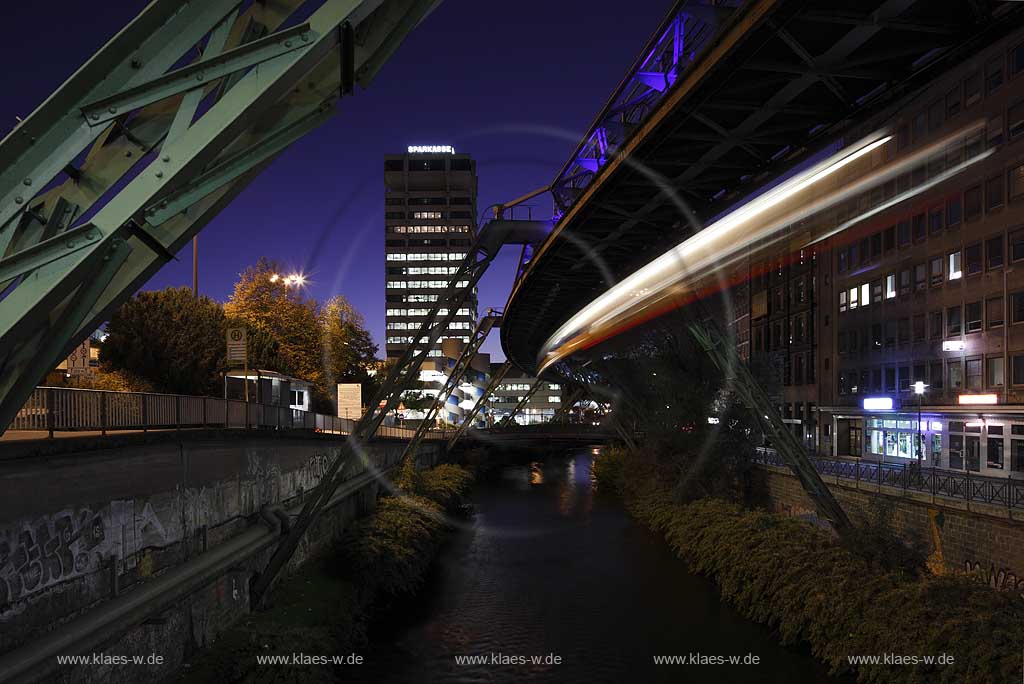 Wuppertal-Elberfeld Doeppersberg Blick mit Schwebebahn und Wupper zum Sparkassen Hochhaus mit Lichtinstallation Lichtwelle am Stahlgeruest zur blauen Stunde; Wuppertal-Elberfeld Doeppersberg aereal railway at blue hour, with illumination lightwave