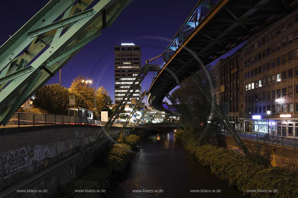 Wuppertal-Elberfeld Doeppersberg Blick mit Schwebebahn und Wupper zum Sparkassen Hochhaus mit Lichtinstallation Lichtwelle am Stahlgeruest zur blauen Stunde; Wuppertal-Elberfeld Doeppersberg aereal railway at blue hour, with illumination lightwave