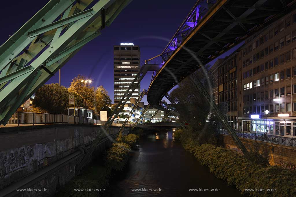 Wuppertal-Elberfeld Doeppersberg Blick mit Schwebebahn und Wupper zum Sparkassen Hochhaus mit Lichtinstallation Lichtwelle am Stahlgeruest zur blauen Stunde; Wuppertal-Elberfeld Doeppersberg aereal railway at blue hour, with illumination lightwave