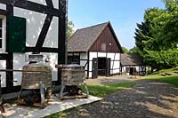 Bergisch Gladbach Bensberg, Bergisches Museum fuer Bergbau Handel und Gewerbe, Blick ueber Kopftsteinplaster Weg, Handwerkerwohnhaus links und Schmiede; Museum of mining and trading