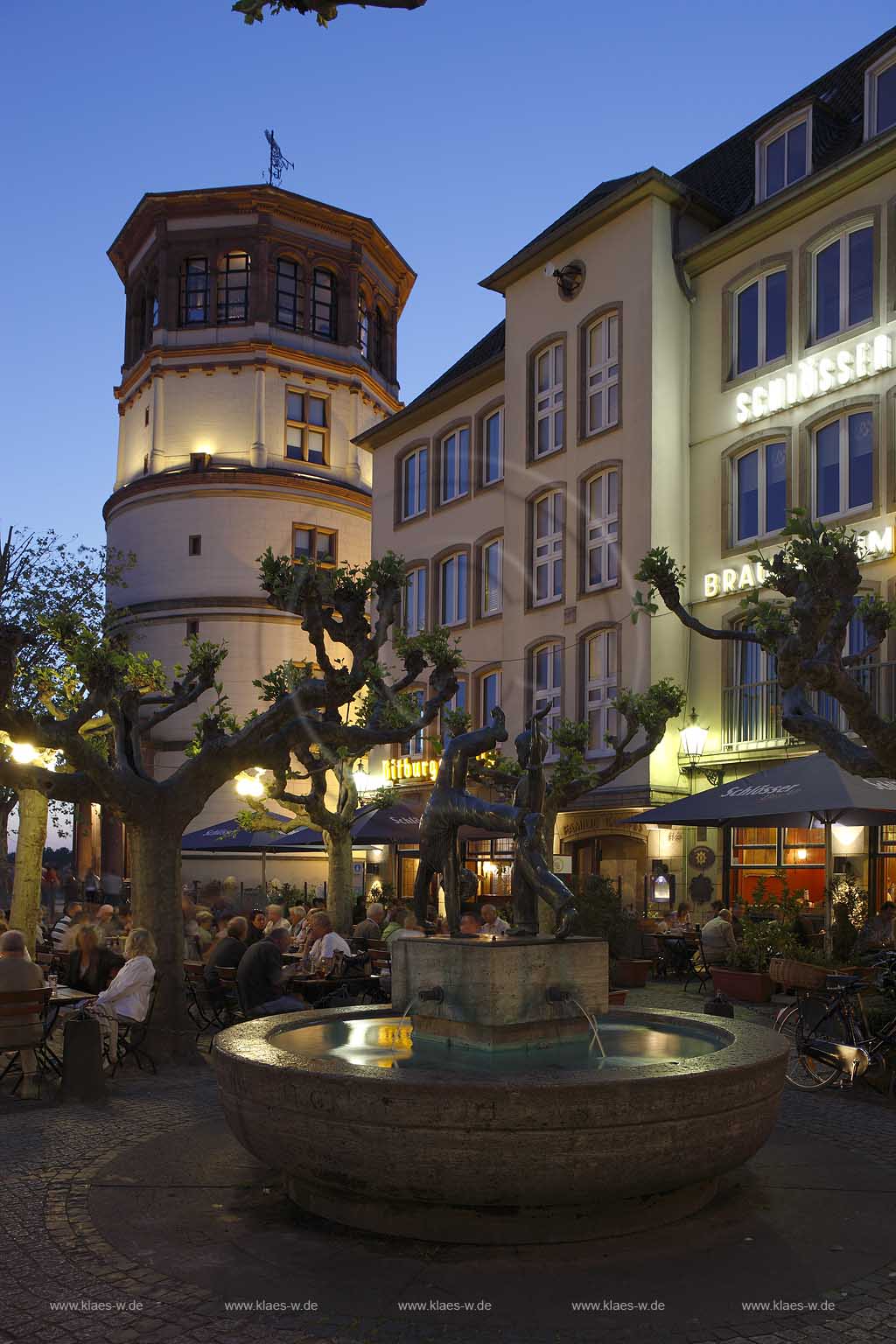 Altstadt, Dsseldorf, Duesseldorf, Niederrhein, Bergisches Land, alter Schlossturm und Radschlgerbrunnen, Radschlaegerbrunnen am Burgplatz vor der Brauerei zum Goldenen Ring mit Menschen, essen, trinken zur blauen Stunde 