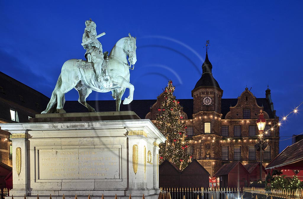 Duesseldorf Altstadt Markt Blick vom Weihnachtsmarkt mit Jan Wellem Reiterstandbild, dem Johann Wilhelm von der Pfalz Denkmal und einem geschmueckten Weihnachtsbaum zum Rathaus waehrend der blauen Stunde illuminiert; Old town marked place at Christmas market with Chrismas tree Jan Wellem memorial and guildhall during blue houre illuminated