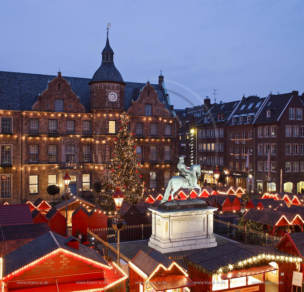 Duesseldorf Altstadt Markt Blick ueber den Weihnachtsmarkt mit Jan Wellem Reiterstandbild, dem Johann Wilhelm von der Pfalz Denkmal und einem geschmueckten Weihnachtsbaum zum Rathaus waehrend der blauen Stunde illuminiert; Old town market place with Christmas market,  Chrismas tree, Jan Wellem memorial and guildhall during blue houre illuminated