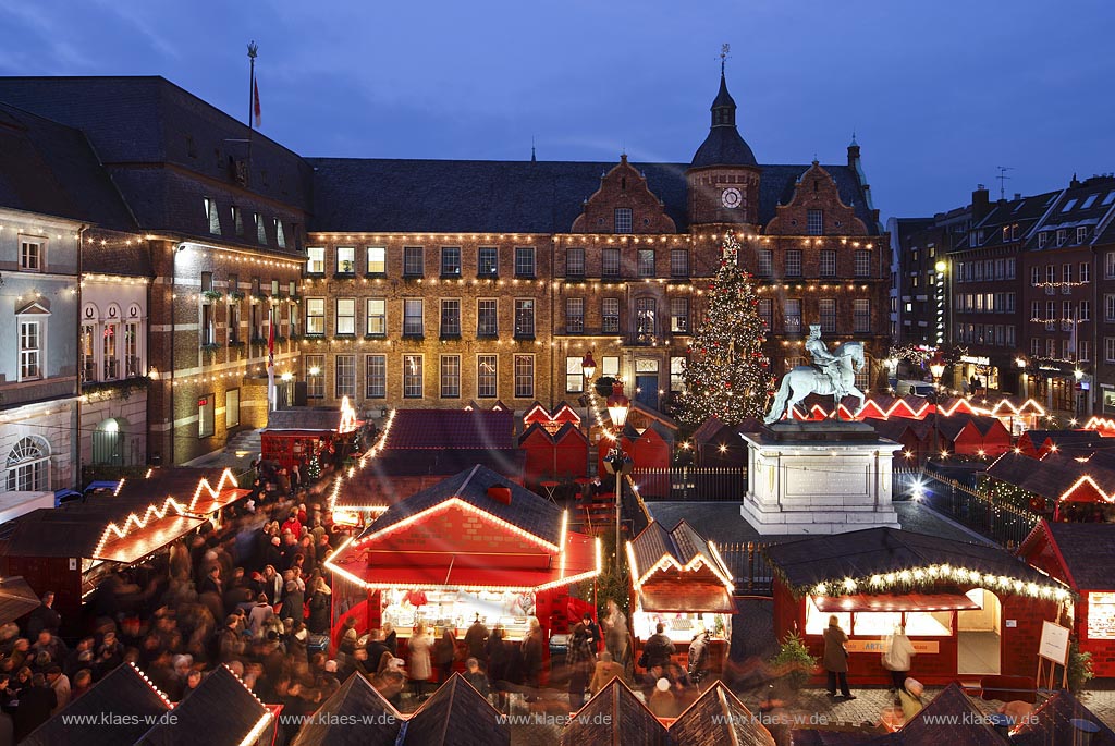 Duesseldorf Altstadt Markt Blick ueber den Weihnachtsmarkt mit Jan Wellem Reiterstandbild, dem Johann Wilhelm von der Pfalz Denkmal und einem geschmueckten Weihnachtsbaum zum Rathaus waehrend der blauen Stunde illuminiert; Old town market place with Christmas market,  Chrismas tree, Jan Wellem memorial and guildhall during blue houre illuminated