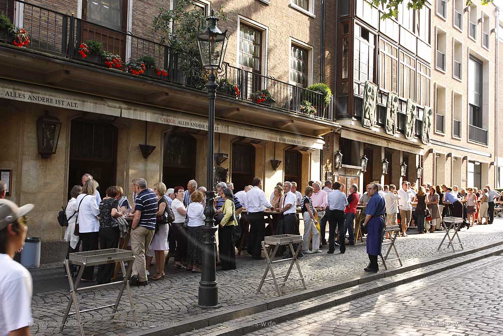 Blick auf Brauerei, Kneipe, Gasthaus Uerige in Dsseldorf, Duesseldorf-Altstadt mit Sicht auf Besucher, Gaeste und Koebesse vor dem Lokal an Stehtischen beim Verzehr von Altbier